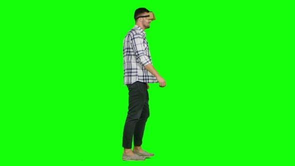 Man Plays Virtual Augmented Reality Game Using Head Mounted Display. Green Screen