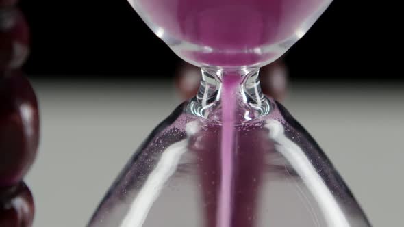 Hourglass in Wooden Stand. Pink Sand. Close Up