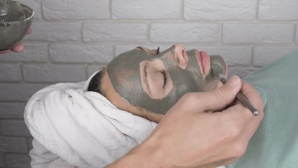 A Woman Applies a Face Mask of Clay on Face