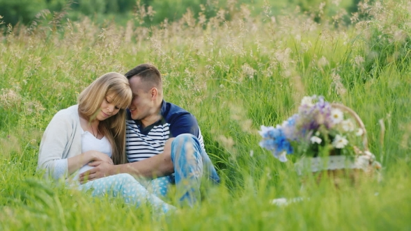 Future Parents Relaxing In a Park. A Pregnant Woman With Her Husband