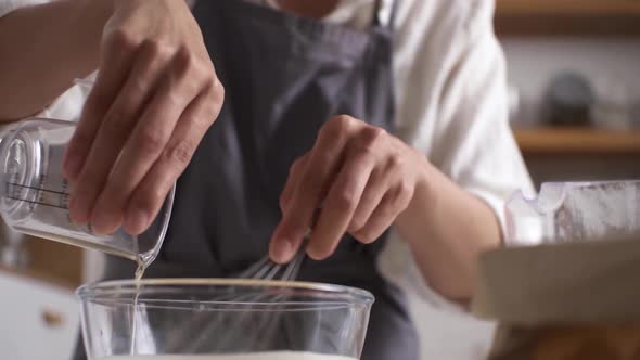 Pouring Oil In Glass Bowl For Making Dough, Then Stirring With A Whisk, Close. Measure Out Vegetable