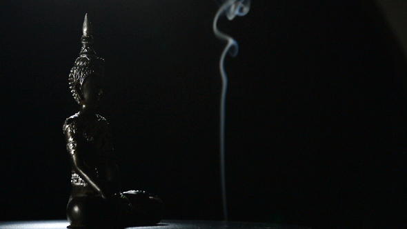 Buddha Figure in Rotation on Black Background alt