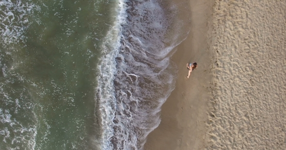 Morning Jogging Girl Along The Surf Line Of The Sea Beach In Summer