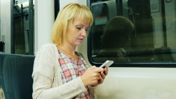 A Woman Goes To The Subway Car, Typing On Mobile Phone