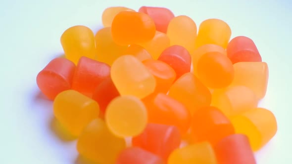 Closeup Texture of Orange and Yellow Multivitamin Gummies in the Form of Bears on White Background