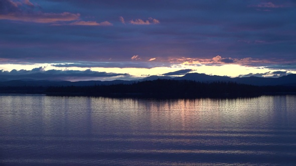 Sea cruise ship along the coast of Alaska. Colorful sunset in the mountains of Alaska.