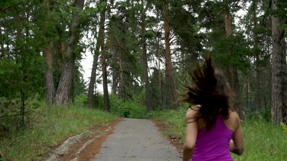 Sporty Girl Runs Through The Park In The Morning