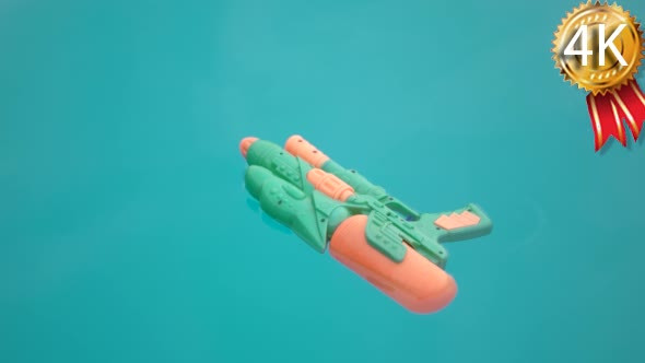 Water Gun Floating in a Blue Swimming Pool Water