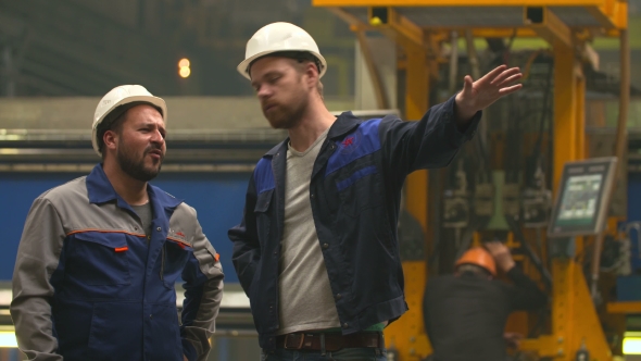 Two Workers Talking About a Job in a Factory