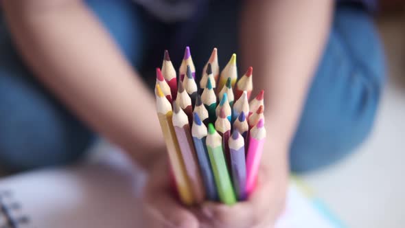 Close Up of a Child Hand Holding Many Colorful Pencils