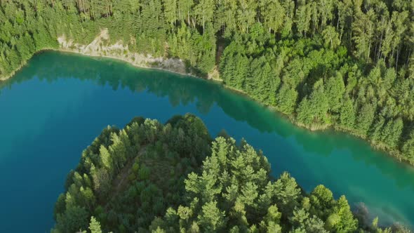 Aerial Top View Amazing Blue Lake Surrounded By Green Pine Forest. Curved Lakeshore and Clean