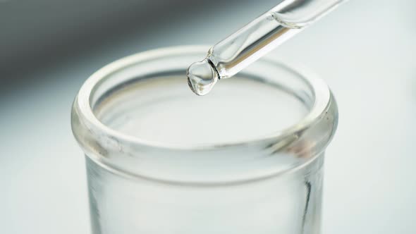 A macro of a pipette adding a drop of fluid to cylindrical test tube. Medical Research, Analysis.