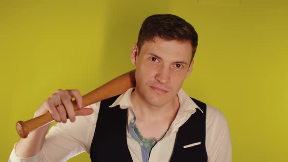 Man on strict face posing with wooden bat.