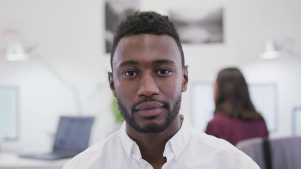 Portrait of smiling african american businessman looking at camera in modern office