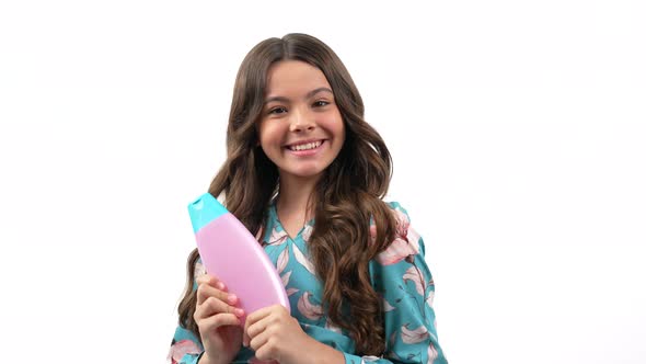 Cheerful Kid Girl with Curly Hair Offer to Wash Hair with Teen Shampoo Product Presenting Product