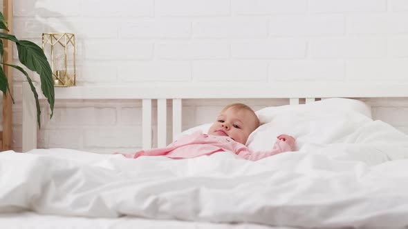 Happy Child Girl Having Fun Jumping and Playing Funny Active Game in Parents Bed Bouncing Fooling