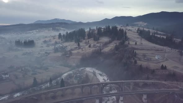 Flight Over the Village and Railway Bridge in the Carpathian Mountains