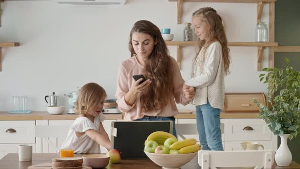 Busy Irritated Mother Tries To Work Remotely, Daughters Interfere with Mother's Work.