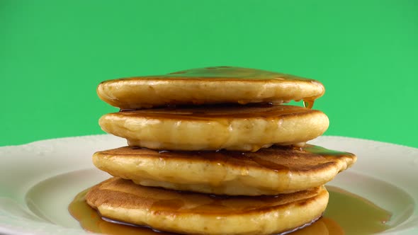 American pancakes with maple syrup on a green background.