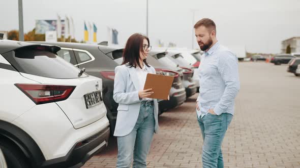 Male Customer Having Conversation with Competent Saleswoman While Choosing Car