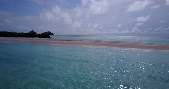 Daytime overhead island view of a white sand paradise beach and blue water background in colourful