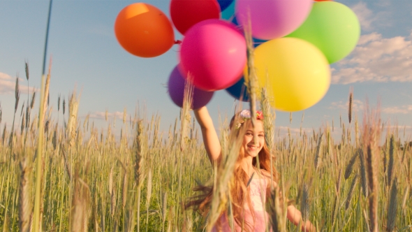 Young Girl Spinning Around In Wheat Field With Colour Balloons During Sunset