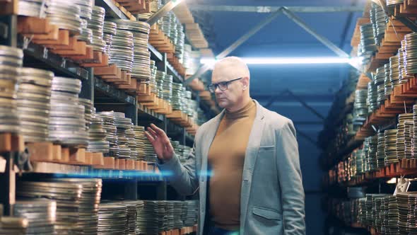 A Man in Glasses is Walking Through the Movie Archive