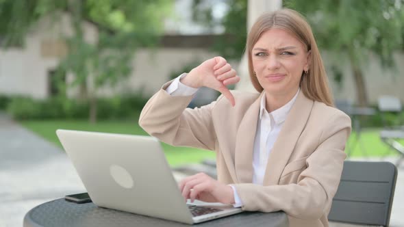 Thumbs Down By Young Businesswoman with Laptop in Outdoor Cafe