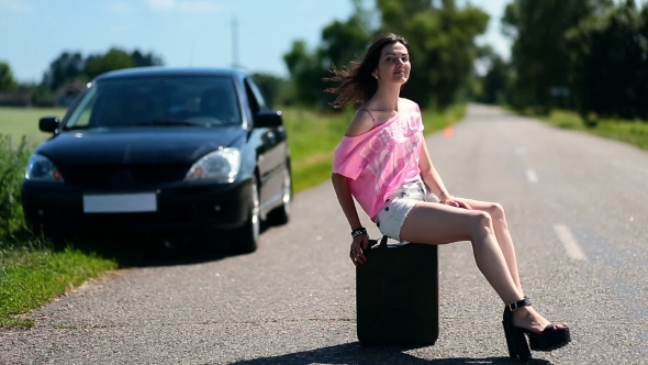 Lovely Woman Sitting On Canister On Country Road