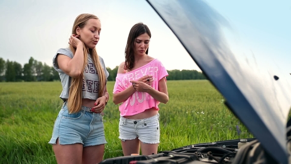 Cute Women Standing Near Opened Hood Of Broken Car