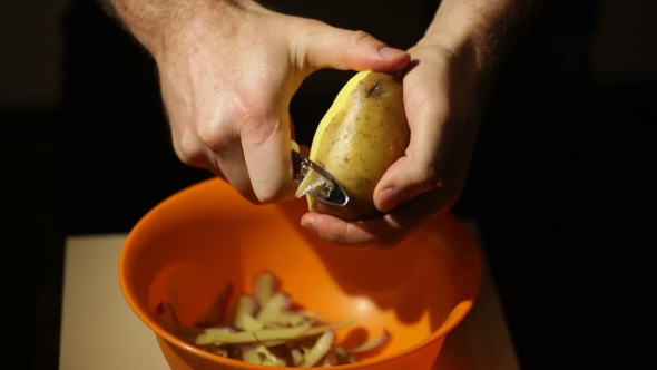  View Of a Male Hand Peeling An Organic Potato