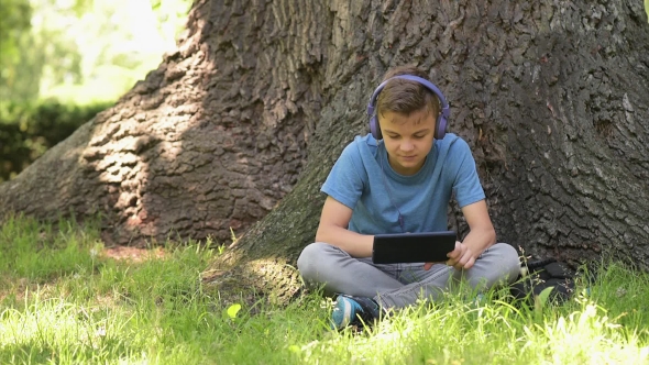 Boy With Tablet At Park