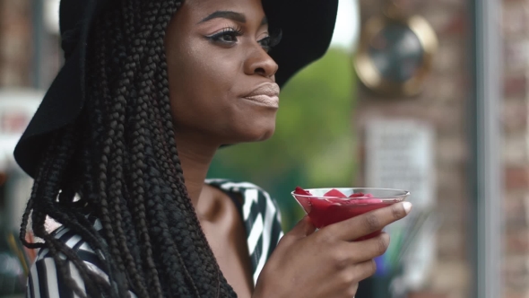 Sexy And Thoughtful African American Lady In Black Hat And Striped Vogue Dress With Cool