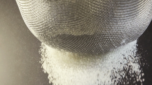 Flour Falling Through a Metal Sieve