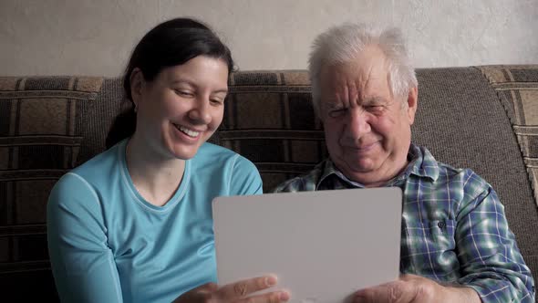 Woman And Elderly Man Communicate To Video Call Over Internet