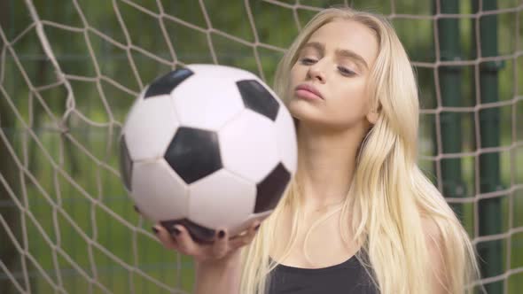 Close-up of Young Female Goalkeeper Posing with Ball on Outdoor Playground. Portrait of Confident