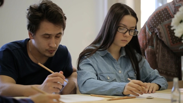 Focused Young Woman With Glasses And Young Man Learn To Draw On Drawing Courses.