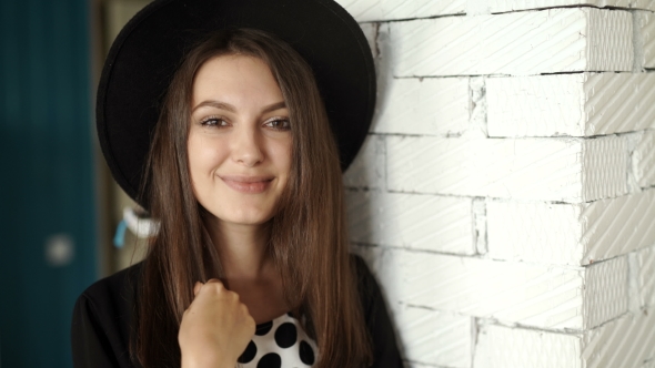 Woman With Toothy Smile Touching Hat With Fields .