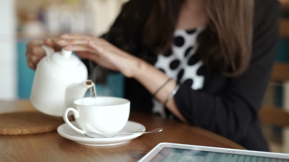 Woman Pouring Milk In Mug From Kettle