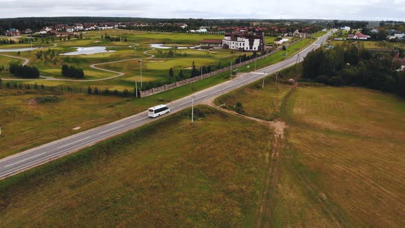 Aerial Shot of White Car Riding Through Rural Road. Countryside Road with Cars on Summer Day.