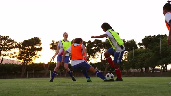 Female soccer player tackling down another player on soccer field. 4k