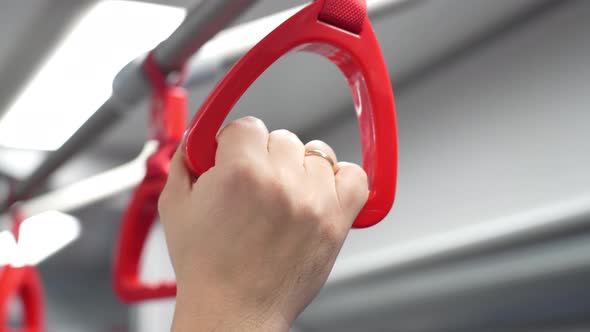 Closeup View Male Hand Holding Looped Handle in Urban Public Transportation While Traveling to Work