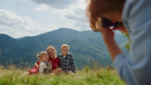 Father Taking Photos Family Sitting Grass Mountain Meadow