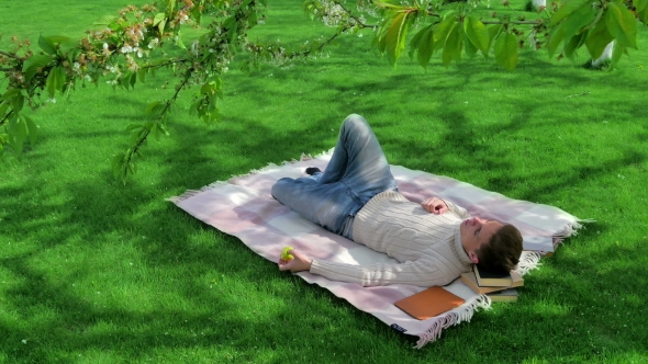 Young Guy Eating Apple In The Yard