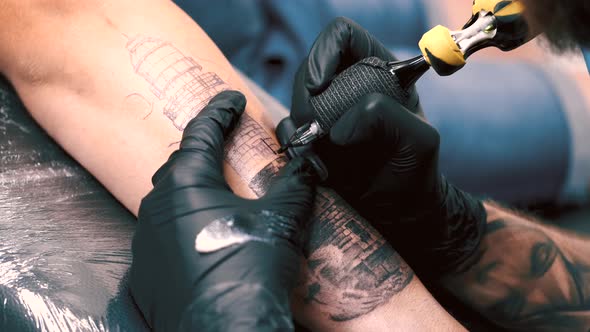 Male Tattoo Artist Tattooing a Client