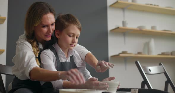 Young Mother and Her Cute Baby Boy Son Work Together on Potter Wheel