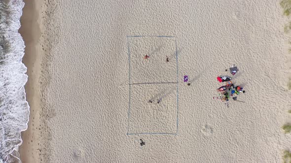 AERIAL: Young People Plays Volleyball on a Sand on a Lovely Evening