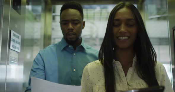 Video of diverse woman and man walking and talking in office