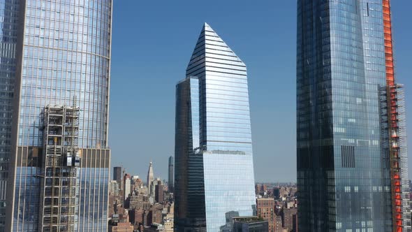 aerial drone truck right as the sun shines, glistens & reflects off of Ten Hudson Yards and the othe