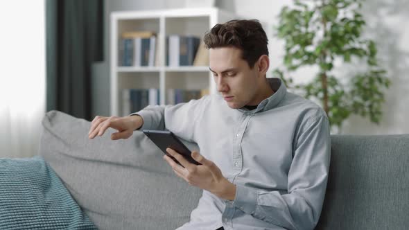 Man Using Digital Tablet at Living Room